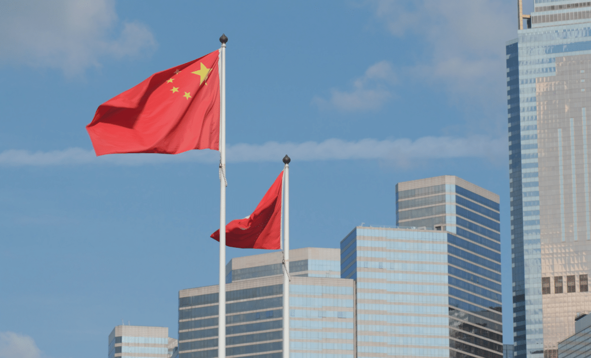 Chinese Flags Flying From Pole in Front of Modern Skyscrapers