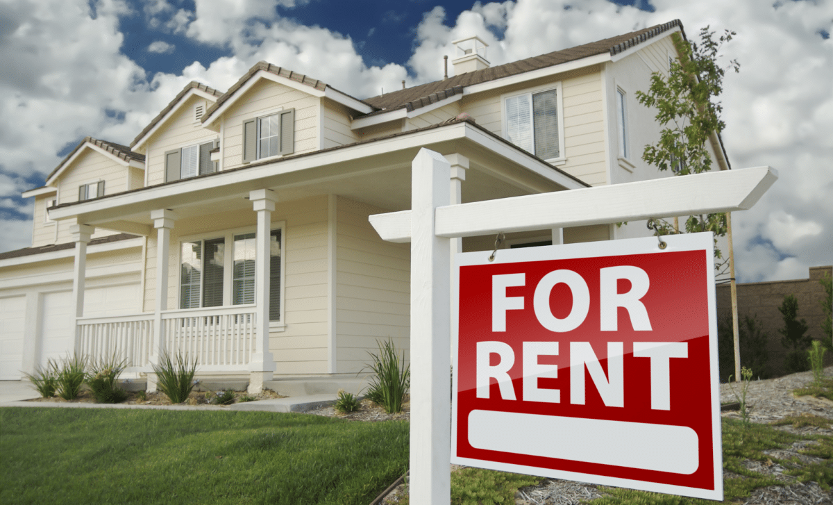 Rental - White Suburban House with "For Rent" Sign in its Front Yard