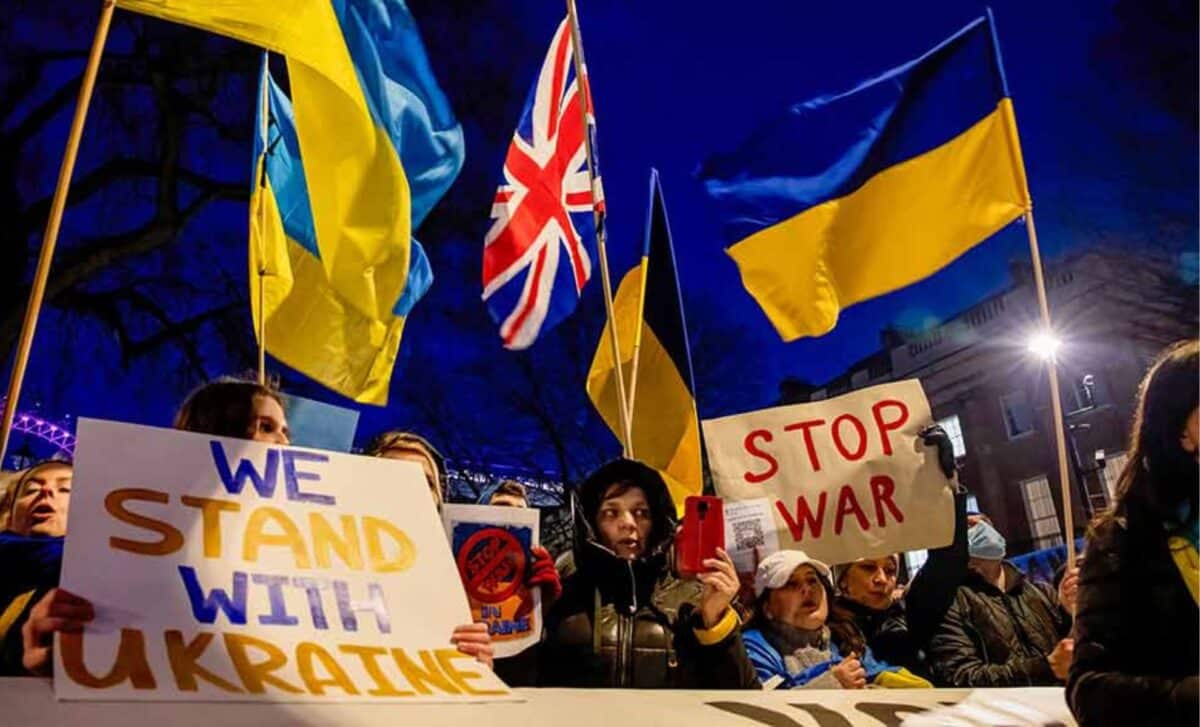 Group Of People Holding Up Signs And Flags In Support Of The Ukrainian People.