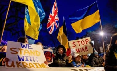 Group Of People Holding Up Signs And Flags In Support Of The Ukrainian People.