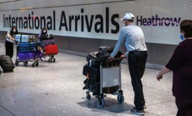 People Pushing Carts Full Of Luggage At The International Arrivals Area In Heathrow