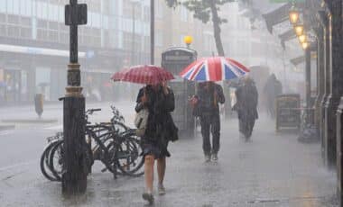 People Walking In The Pouring Weather, Holding Umbrellas.