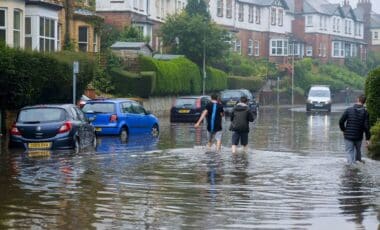 Rainy Weather With People Walking In A Flooded Street