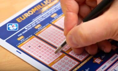 A Man Checking The Boxes Of A Euromillions Ticket