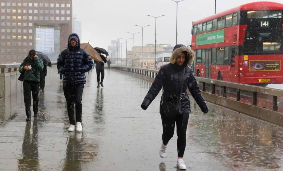 UK Weather : People Walking On A Sidewalk On A Rainy Day In The City.