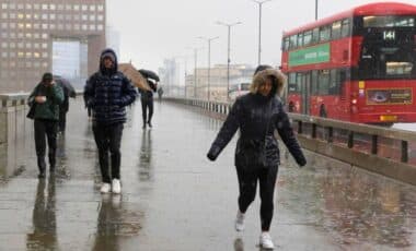 UK Weather : People Walking On A Sidewalk On A Rainy Day In The City.