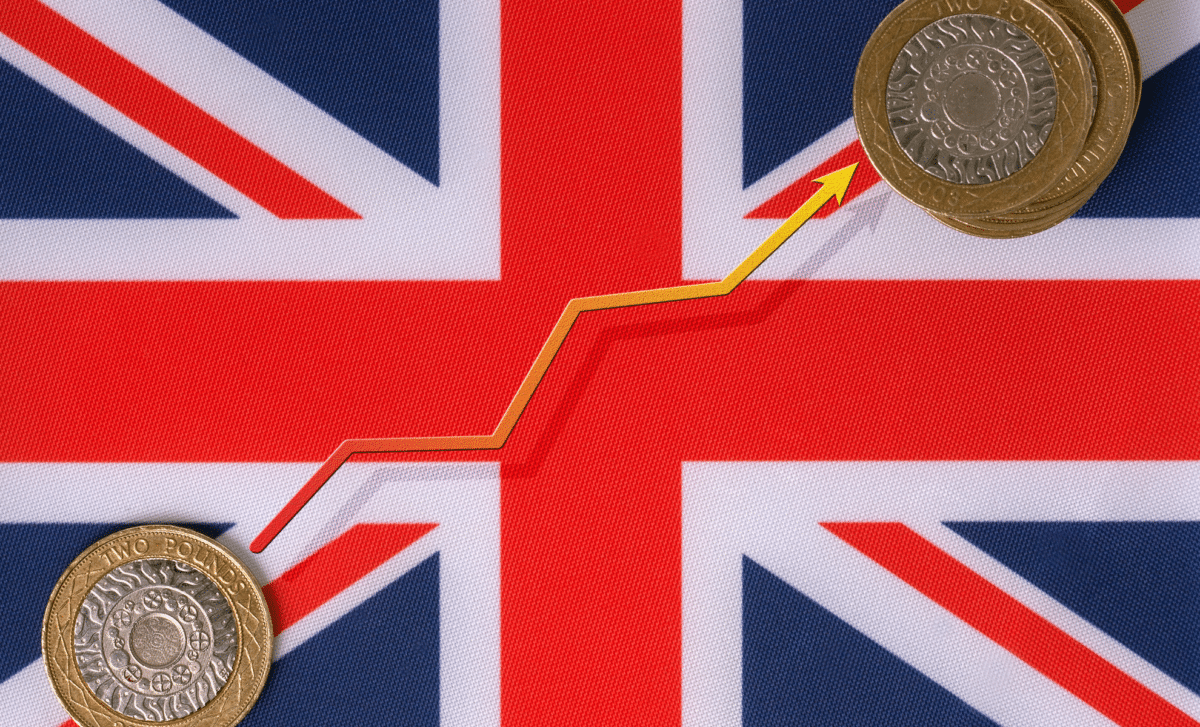 National Flag of the United Kingdom with Two Pound Coins and A Yellow Upward Line Graph, Symbolising UK Economy Growth