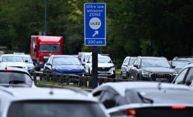 View Of A Sign Indicating An Ultra Low Emission Zone In London, Surrounded By A Large Number Of Cars