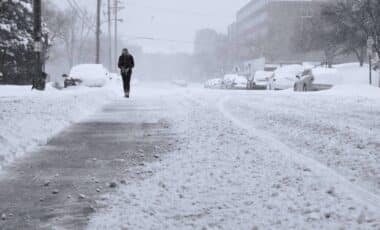 A Person Walking On A Snowy Road