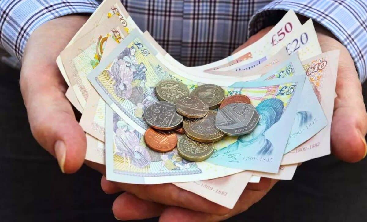 UK State Pensioner holding cash and coins