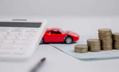 Car Insurance Papers, Calculator, Miniature Red Car, Pen and Coins