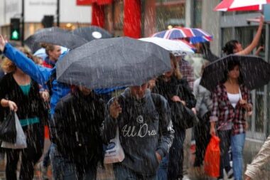 People Walking in the Rain - UK Retail Sales Drop in June Due to Cold Weather and Rising Cost of Living