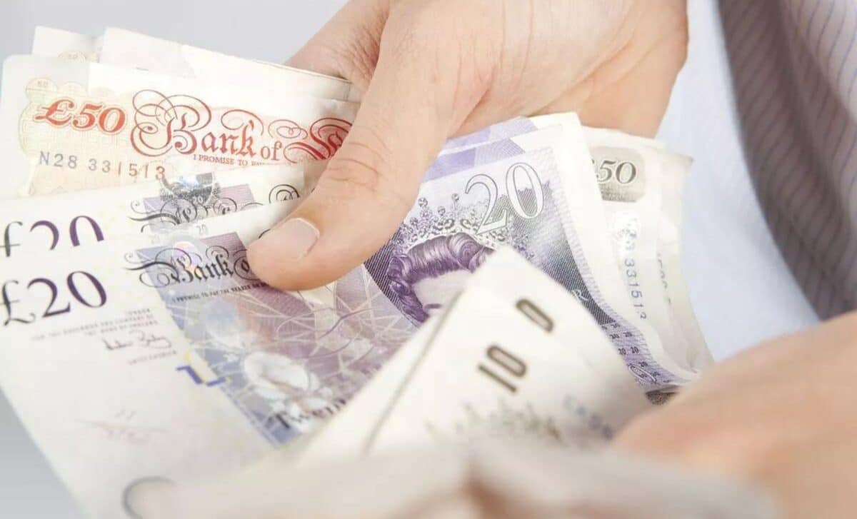 Hands Holding A Collection Of British Banknotes, Including £50, £20 And £10 Notes