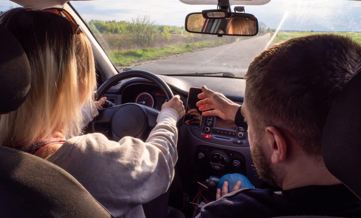 Driving Instructor Teaching A Woman How To Drive