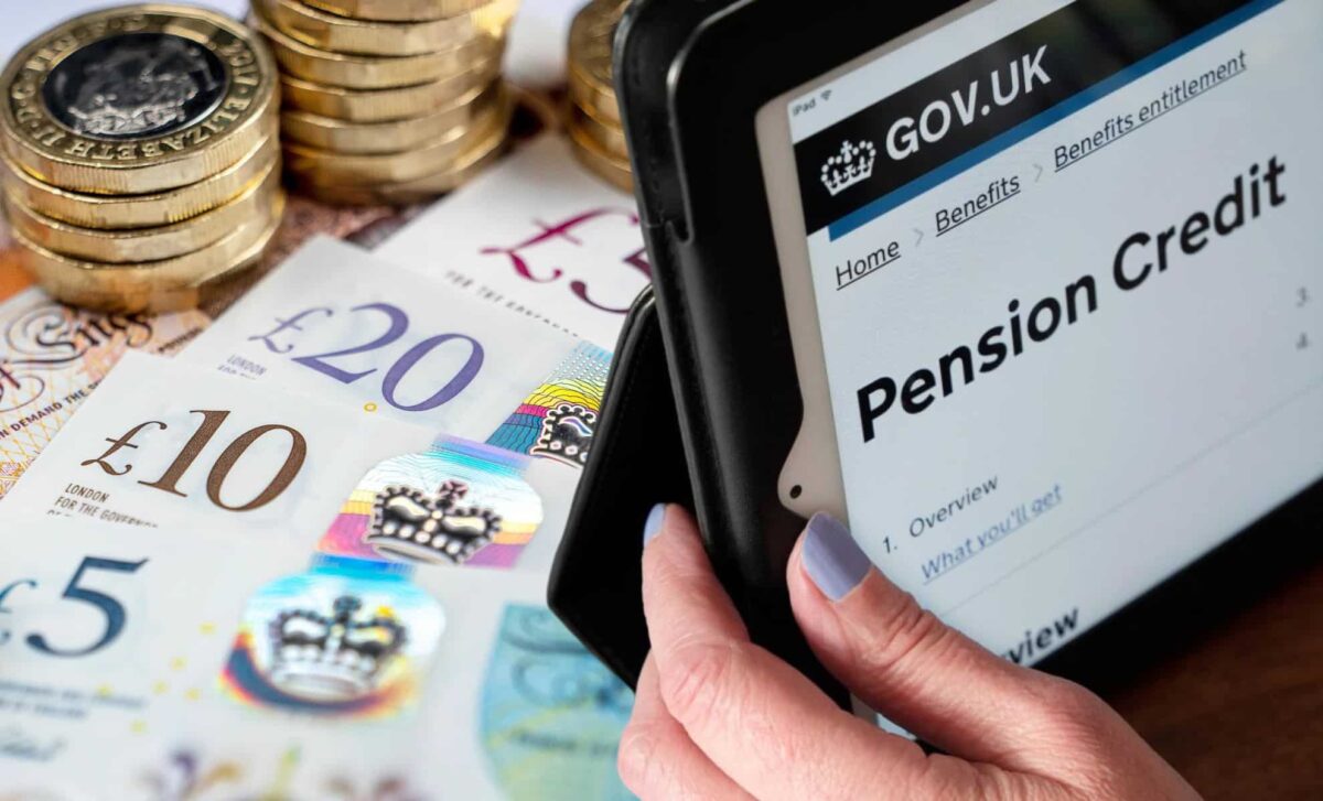 A Person Holding A Tablet Browsing The DWP Page Related To Pension Credit.