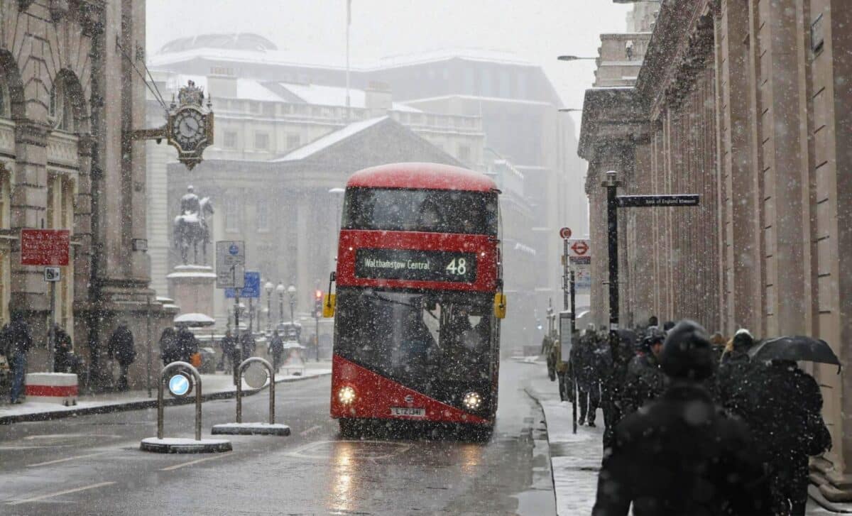 A Red London Bus Makes Its Way Through The Snow As A Snowstorm Descends On Central London.