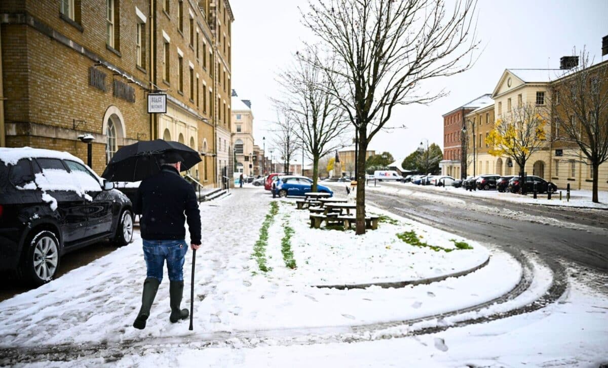 A man walks on snow covered pavement in Poundbury