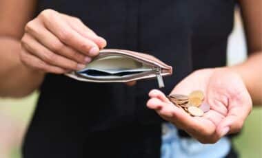 Households - A Photo Of A Person's Hands Holding A Small Purse Or Wallet.