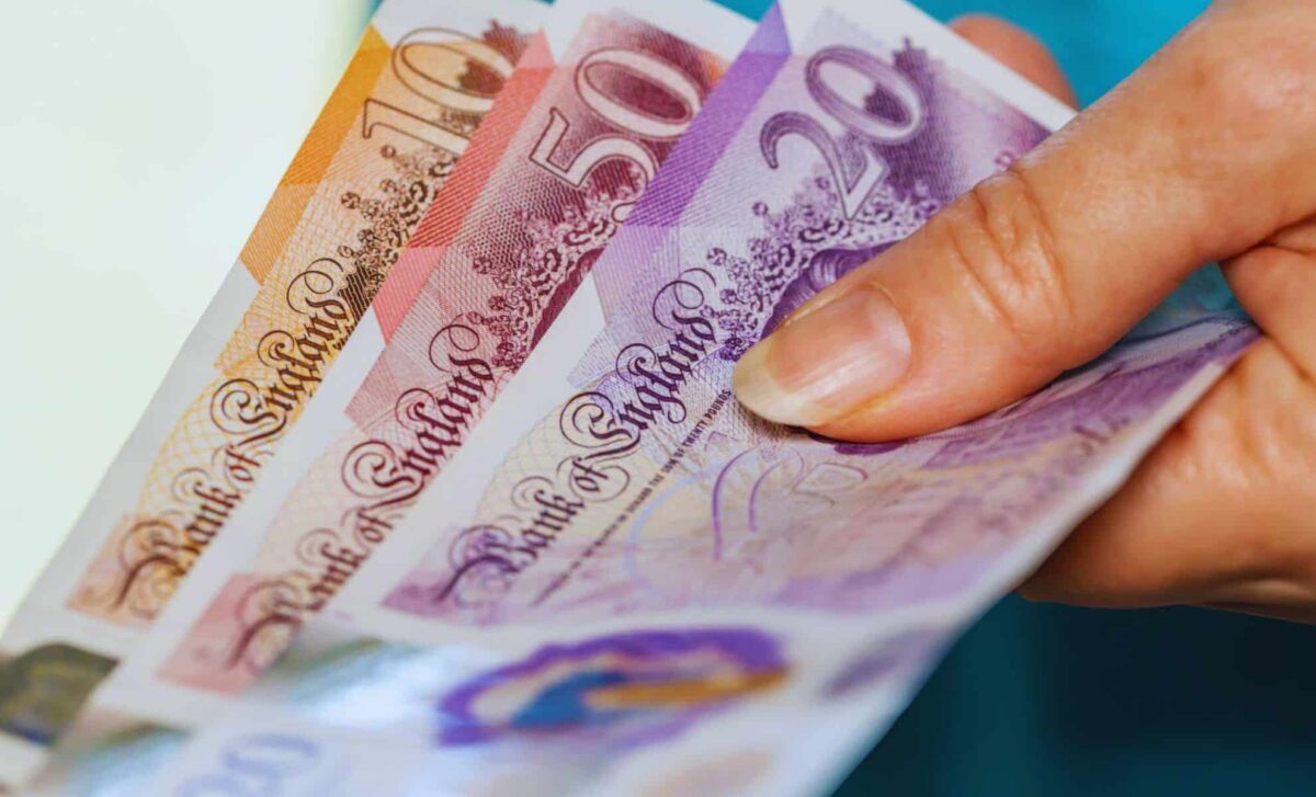 £200 Support - British Woman Holds English Pounds In Her Hand