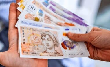 Woman counting British pound bills support