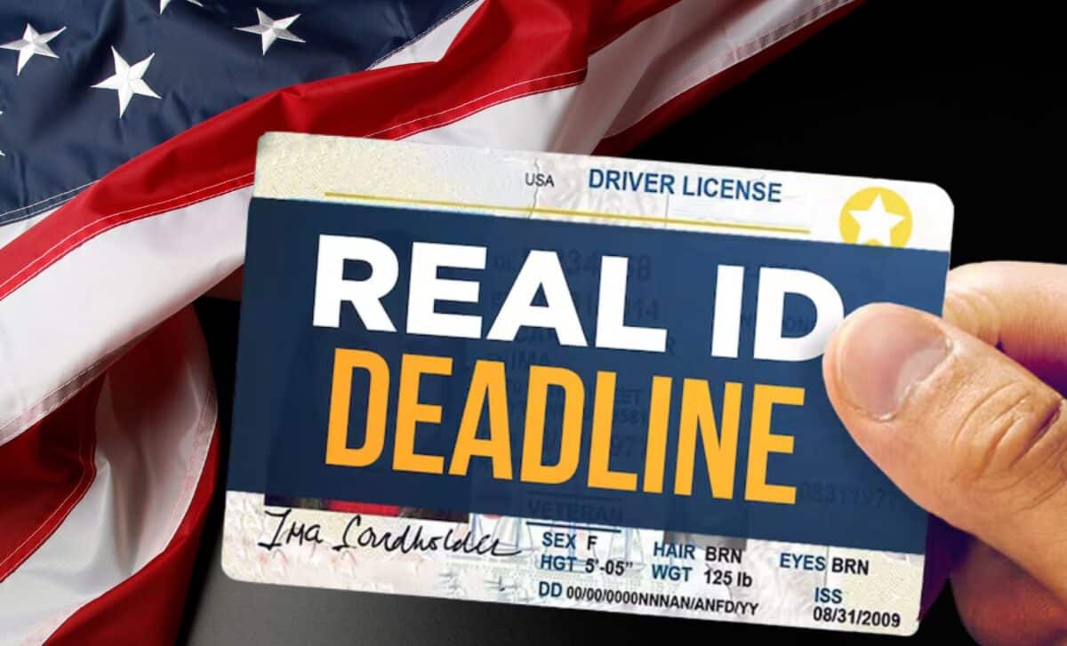 Hand holding a U.S. driver's licence with REAL ID DEADLINE in bold text