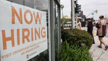 Jobs-storefront with a large sign in the window that reads NOW HIRING in bold