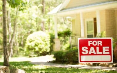 Housing Market Home for sale with real estate sign.