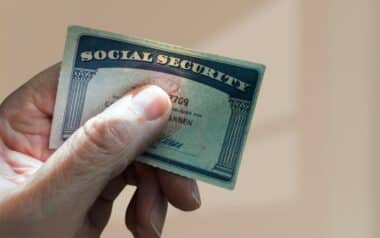A hand holding a Social Security card,