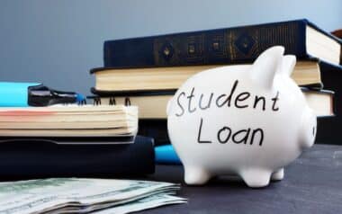 Student loan written on a piggy bank and money.