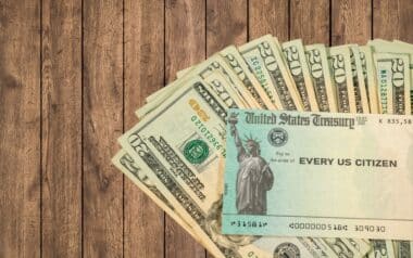 Stack of Twenty US Dollar Bills and Federal Stimulus Payment Check