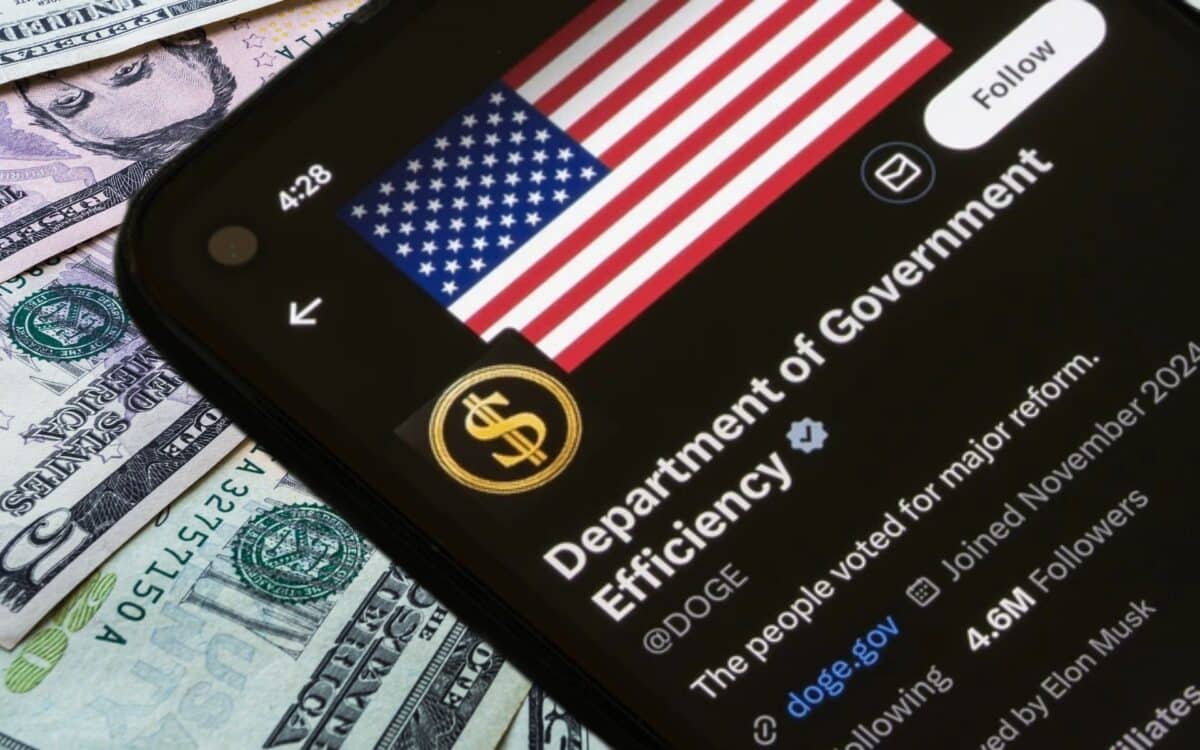A smartphone shows the DOGE agency profile over U.S. dollar bills, symbolizing government savings and taxpayer refunds.