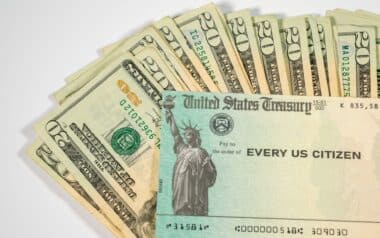 Stack of Twenty US Dollar Bills and Federal Stimulus Payment Check