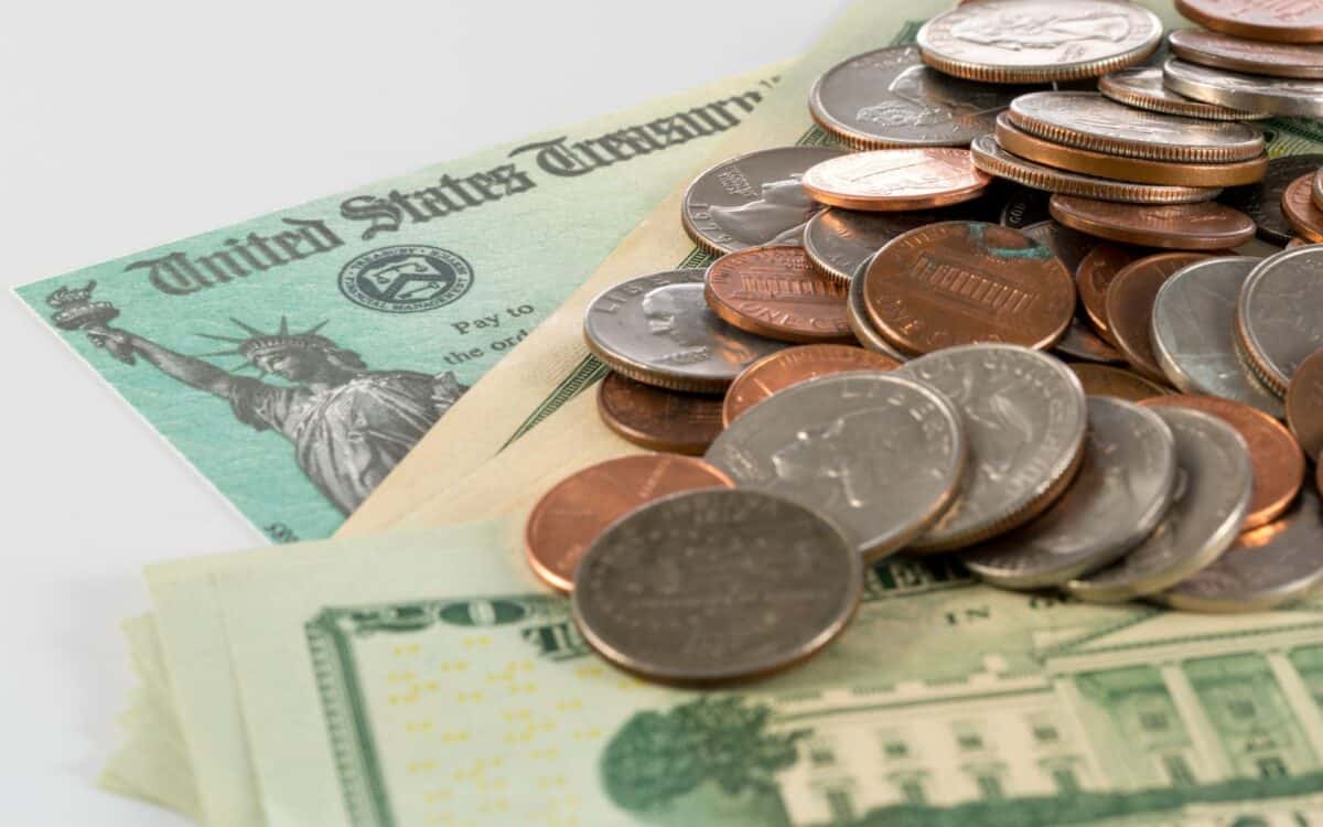 Federal Stimulus Payment Check with Stack of Cash and Coins