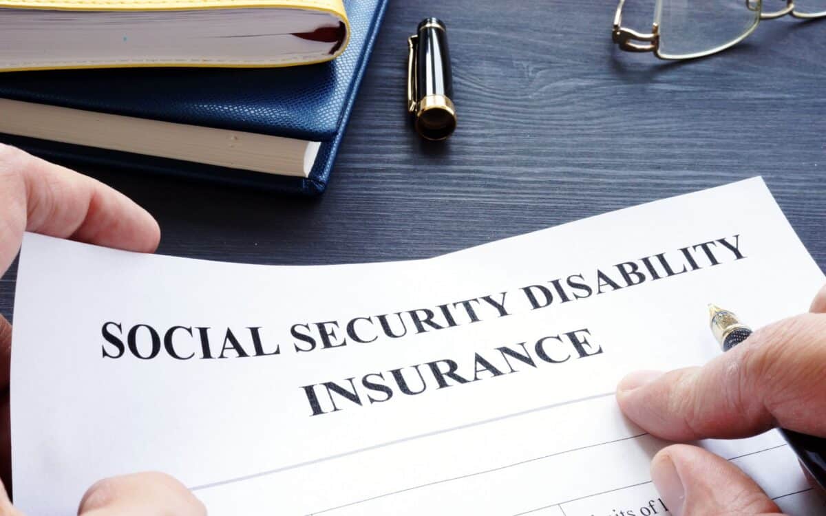 Man is holding Social Security Disability Insurance SSDI policy.