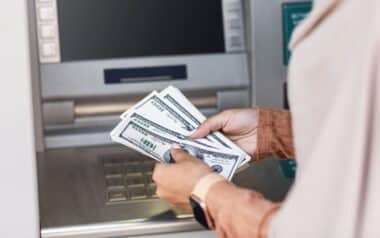 Female Counting Dollar Bills Standing in