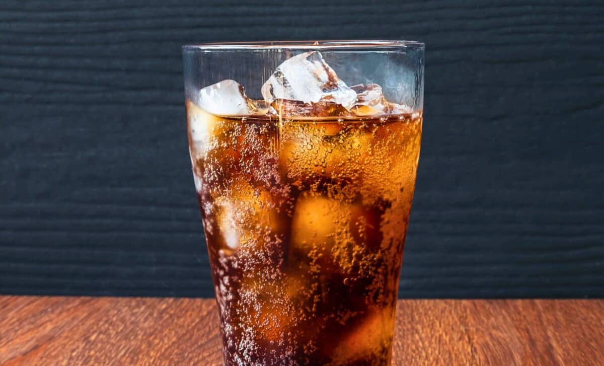 A glass of chilled soda with ice cubes