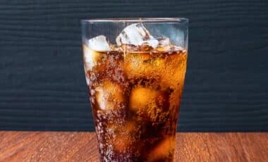 A glass of chilled soda with ice cubes