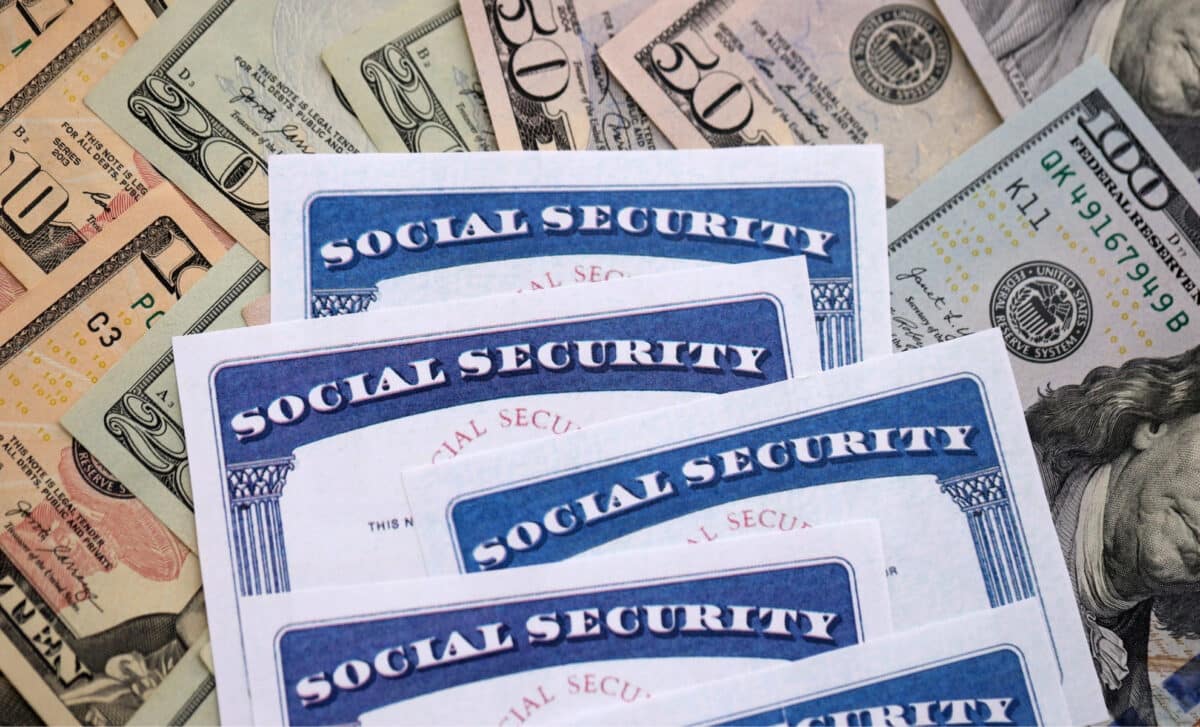Close-up of Social Security cards on numerous US dollar banknotes