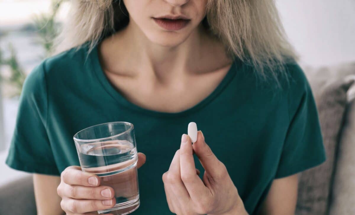 Young Woman with Pill and Glass of Water