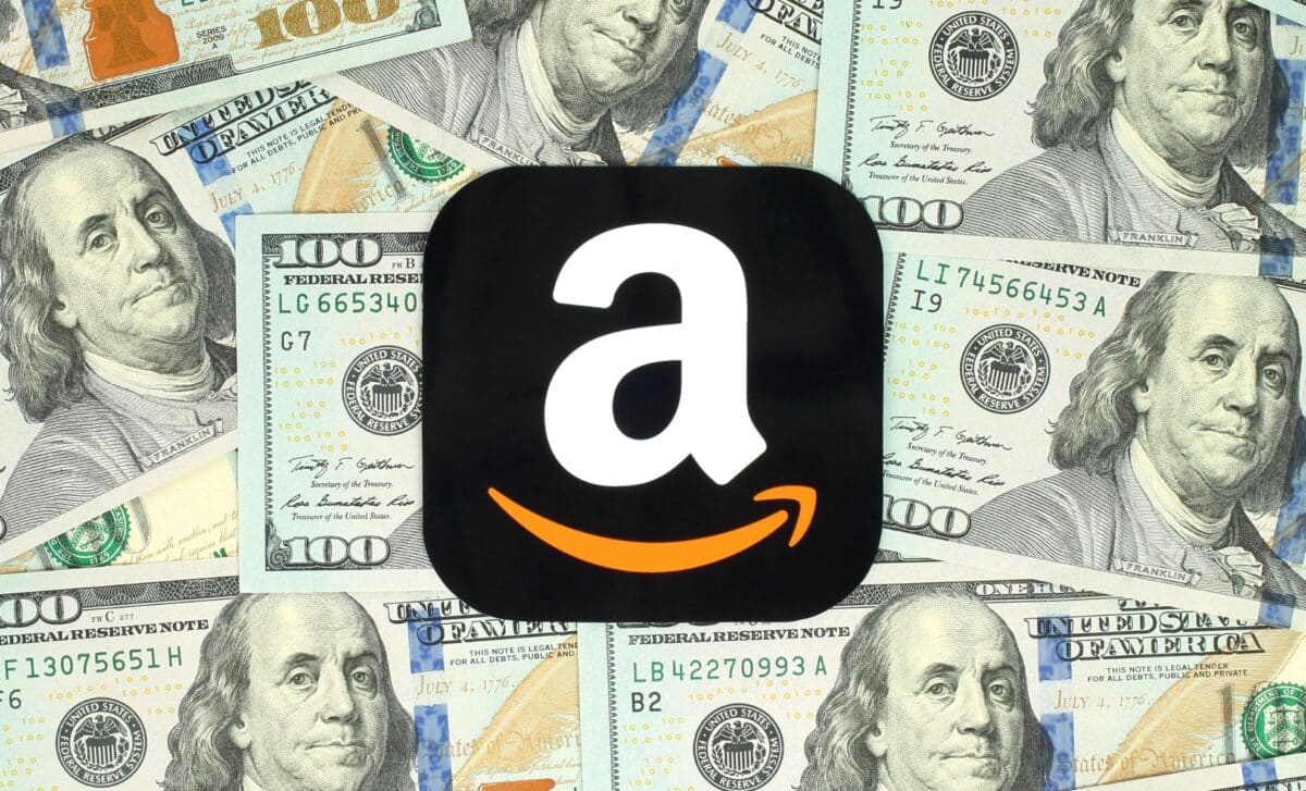 Amazon icon printed on paper and placed on money background.