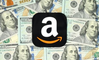 Amazon icon printed on paper and placed on money background.