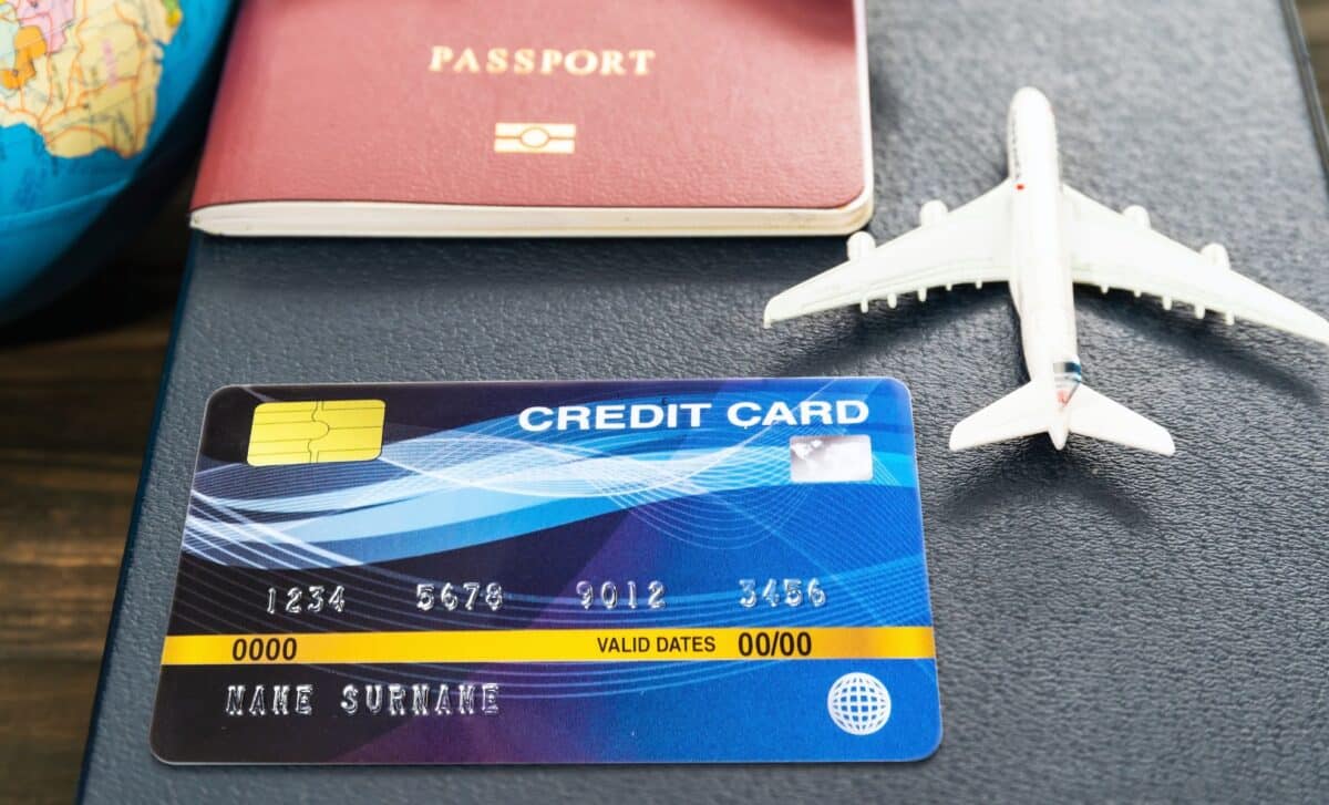 Credit card and airplane model on a wooden table
