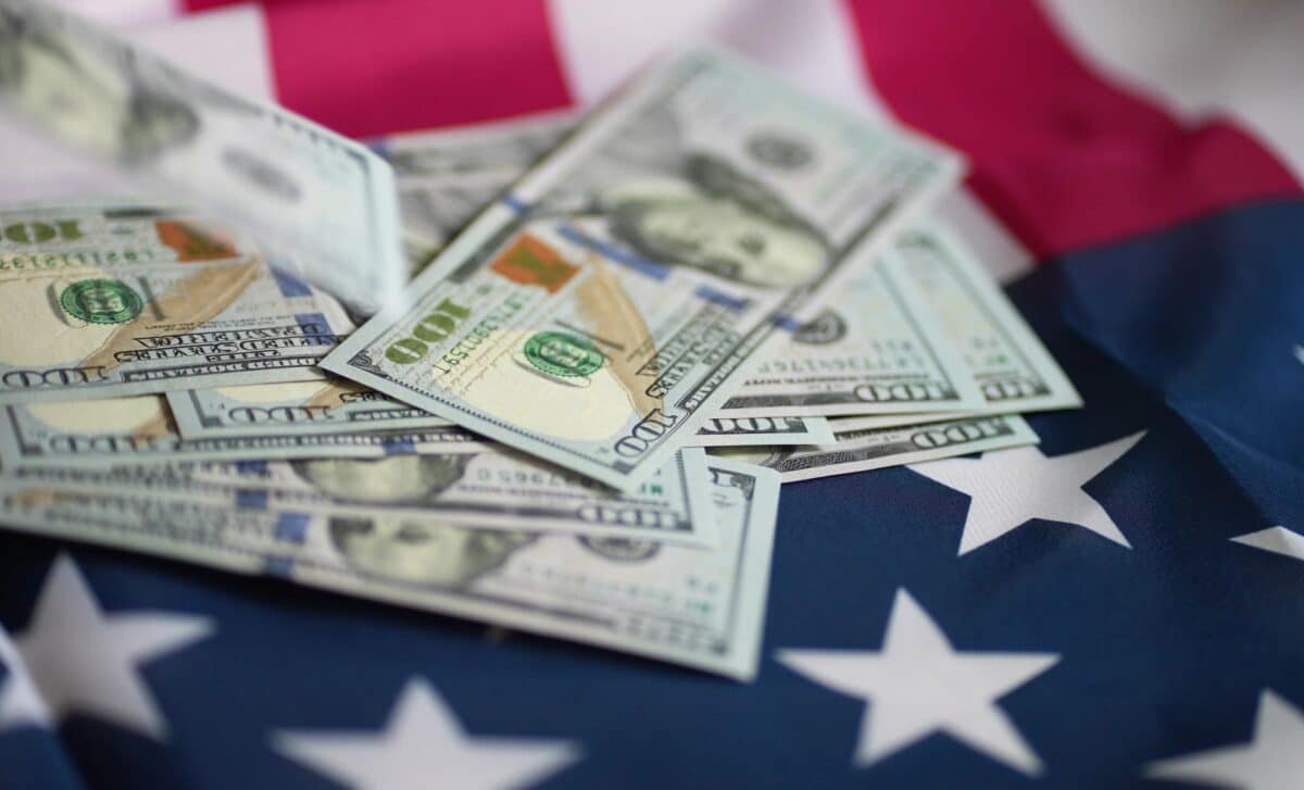 One-hundred dollar bills on american flag