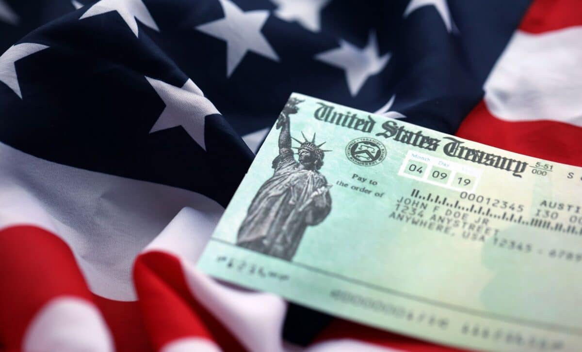 U.S. Treasury refund check over a close-up image of the American flag.