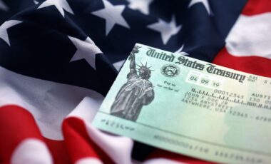 U.S. Treasury refund check over a close-up image of the American flag.